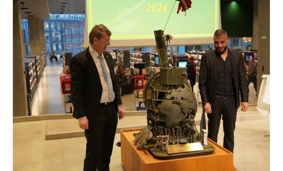 Aarhus Kommune har ifølge ministeren ydet en særlig indsats for veteraner. Her ses forsvarsminister Troels Lund Poulsen (V), som overrakte prisen til Rabih Azad-Ahmad (R), som tog imod den på vegne af kommunen.